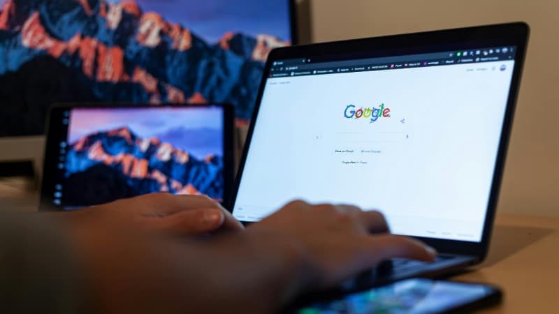 Hands typing on a laptop with Google on screen, in a remote work setup in Milan, Italy., tags: ads gambling - pexel