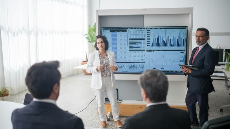 Colleagues discussing financial charts during a corporate meeting in a modern office., tags: 2025 ppc 2026 casino - pexel
