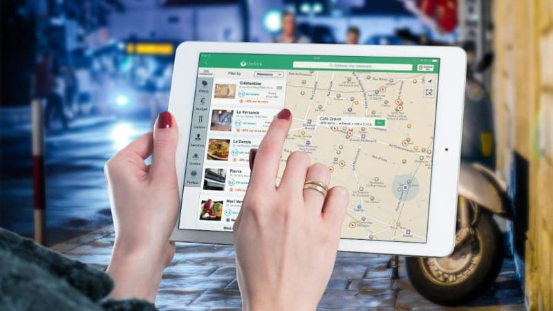 Hands using a digital map on a tablet in an urban setting at night, illustrating navigation and technology., tags: casino affiliate marketing - pexel