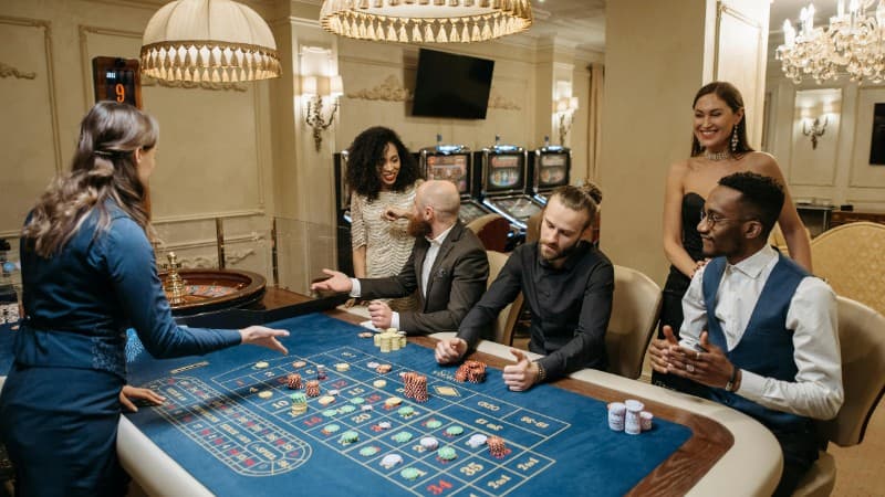 Group of people enjoying a lively night at the casino, playing roulette., tags: fast payouts casino affiliate network - pexel