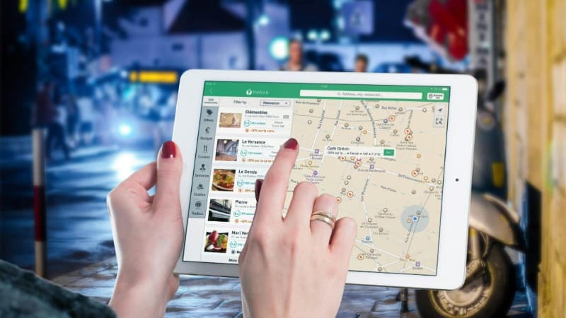 Hands using a digital map on a tablet in an urban setting at night, illustrating navigation and technology., tags: casino local - pexel